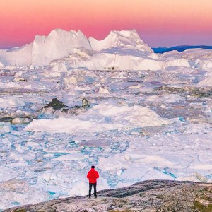 格陵兰旅行远足者旅游人徒步旅行在日落。北冰洋的冒险探险，冰漂浮从冰山的海洋。横幅全景。